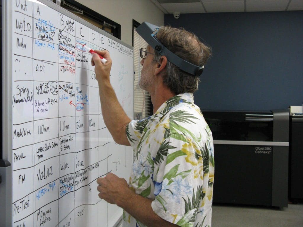 Engineer editing specifications and values on a whiteboard