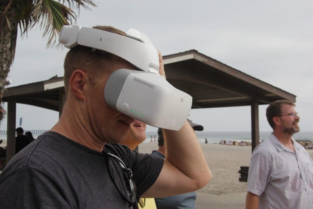 Engineers at the beach flying a drone using a VR headset