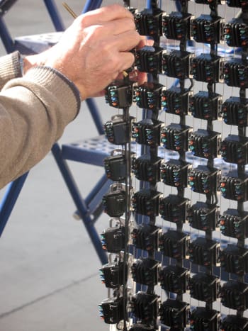 NOVO engineer installing a 16-module segment on a flexible mesh outdoor video display